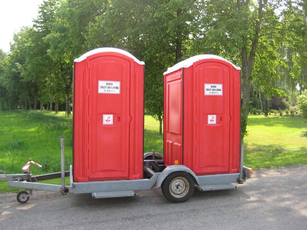 2 røde toiletkabiner på trailer
